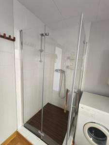 a shower with a glass door next to a washing machine at Puig Rom Pau Vila in Roses +65 photos