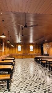 a large room with wooden tables and benches at pra tiksha farm in Karjat