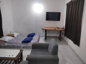 a room with a bed and a table and a tv at 1 Bhk apartment kyle garden baga beech in Baga