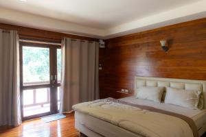 a bedroom with a bed with a wooden wall at โอโซนริมน้ำเขาใหญ่ in Ban Pang Kae