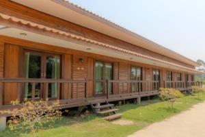 a large wooden building with a row of windows at โอโซนริมน้ำเขาใหญ่ in Ban Pang Kae