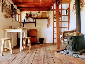 a room with a woodburning stove and a kitchen at Lemon tree hotel in Higashiura