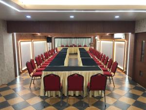 a large conference room with a long table and red chairs at Hotel Afrad International in Kondotti +21 photos