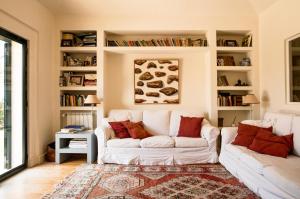 una sala de estar con 2 sofás blancos y una alfombra en Villa Rio Seco en Sintra