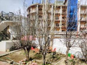 an old building with trees in front of it at Hotel T-Suru Leh in Leh +14 photos