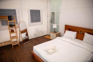 a bedroom with a bed with white towels on it at Ohara Glamping in Kubupenlokan