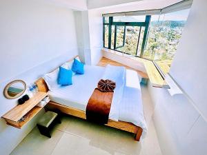 a bedroom with a bed and a large window at Villa đà lạt Trung Nghĩa 1 in Ấp Ða Lợi