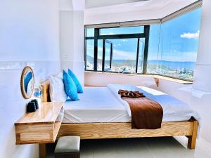 a bedroom with a bed with a large window at Villa đà lạt Trung Nghĩa 1 in Ấp Ða Lợi
