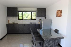 a kitchen with a table with chairs and a refrigerator at Naikabula Villa in Lautoka
