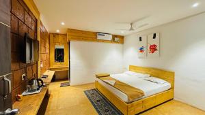 a bedroom with a bed and a television in it at pra tiksha farm in Karjat