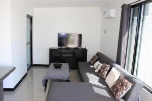 a living room with a couch and a flat screen tv at Naikabula Villa in Lautoka