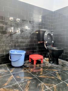 a bathroom with a toilet and a red stool at Hotel T-Suru Leh in Leh