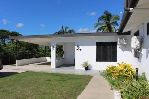 a white house with a porch and a yard at Naikabula Villa in Lautoka