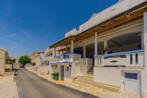 a row of white buildings on a street at B&B Sobe Magdalena in Metajna