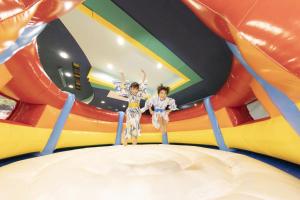 two children on a inflatable ride in a bouncy house at Ooedo Onsen Monogatari Awazu Grand Hotel in Komatsu