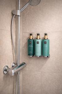 three green shampoo bottles on a shelf in a shower at Klaverhoeve Stene in Ostend +46 photos