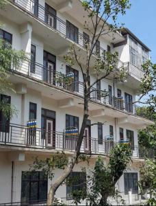 an apartment building with balconies and a tree at Silver oak Hotel and Restaurant in Pāndoh +21 photos