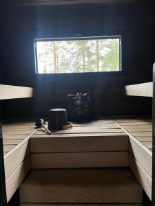 a sauna with a window in a blue room at Lapin Unelma in Äkäslompolo +2 photos