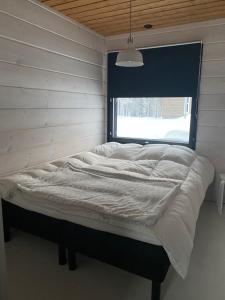 a bed in a room with a window at Lapin Unelma in Äkäslompolo