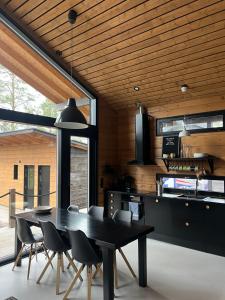 a dining room with a black table and chairs at Lapin Unelma in Äkäslompolo