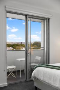 a bedroom with a bed and sliding glass doors at Elevated 2BR & Sofa Bed Apartment in the Heart of Prospect in Prospect
