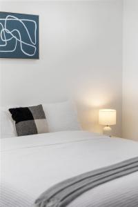 a bedroom with a white bed and a blue picture at Elevated 2BR & Sofa Bed Apartment in the Heart of Prospect in Prospect +9 photos