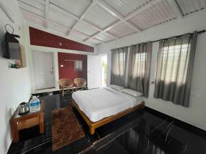 a bedroom with a bed and a table in a room at Green Valley in Kolakambe