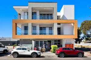 two cars parked in front of a building at Elevated 2BR & Sofa Bed Apartment in the Heart of Prospect in Prospect