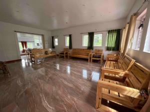 a large room with benches and tables and windows at Green Valley in Kolakambe +5 photos
