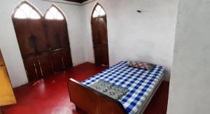 a room with a bed with a blue and white checkered table at Vikram homestay in Malvan