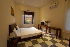 a bedroom with a bed and a desk and a window at Banyan Villa Nha Trang in Nha Trang
