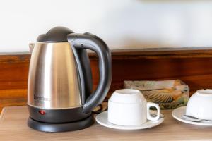 a tea kettle on a table next to a cup at โอโซนริมน้ำเขาใหญ่ in Ban Pang Kae