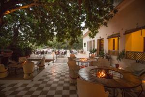a patio with tables and chairs and a fire pit at Royal Heritage Haveli - By Leisure Hotels in Jaipur