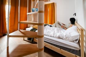 zwei Personen liegen in einem Zimmer auf einem Etagenbett. in der Unterkunft Ypsilon - Pixel in Târgu Secuiesc