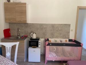 a childs bedroom with a crib and a kitchen at Riverside in Virpazar
