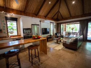 a living room with a kitchen with a table and chairs at Mokusiga Villas in Tangangge