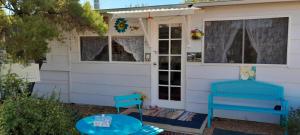 a house with a blue bench and a window at Blue Flower Cottage in Lightning Ridge