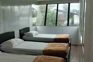 two beds in a room with windows at Cozzy D'Sobahan Resort in Ngadirejo