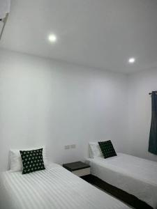 two beds sitting next to each other in a room at DD Bangrak Hotel in Koh Samui