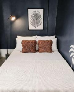 a bedroom with a large white bed with two pillows at El Kim Suites in Boac