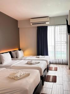 a hotel room with three beds and a window at i-river chiangmai in Chiang Mai +177 photos
