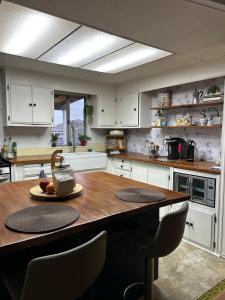 a kitchen with a large wooden table with chairs at 3333 Luz Del Valle Hotel Boutique in Valle de Guadalupe