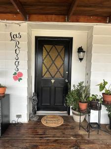 a black door on a house with potted plants at 3333 Luz Del Valle Hotel Boutique in Valle de Guadalupe +49 photos