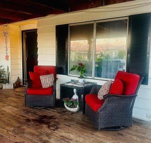 two chairs with red pillows sitting on a porch at 3333 Luz Del Valle Hotel Boutique in Valle de Guadalupe