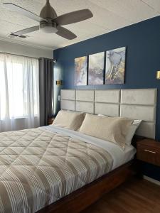 a bedroom with a large bed with blue walls and a ceiling at 3333 Luz Del Valle Hotel Boutique in Valle de Guadalupe