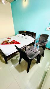 two beds and a chair in a room at Junglee tree stays in Hampi
