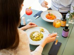 a woman sitting at a table with a plate of food at Art Hotel Tartini in Piran