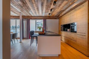 a kitchen with a counter and a table with chairs at AlpenParks Hotel Maria Alm in Maria Alm am Steinernen Meer