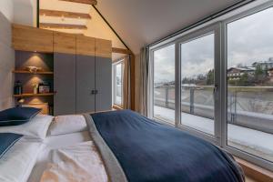 a bedroom with a bed and a large window at AlpenParks Hotel Maria Alm in Maria Alm am Steinernen Meer