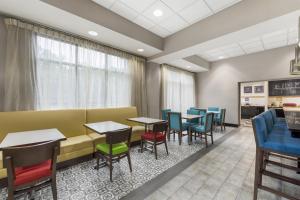 a waiting room with tables and chairs and a couch at Hampton Inn Birmingham/Leeds in Leeds